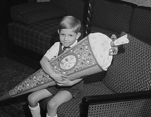 Black and white picture of young German boy holding a schultute or school done, a tradition for children entering grade school