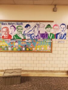 Three Oaks Public School Academy students work with staff to create a mural to go in the hallway celebrating African American historical figures