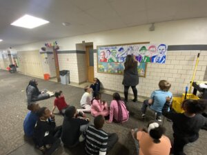 Three Oaks Public School Academy students work with staff to create a mural to go in the hallway celebrating African American historical figures